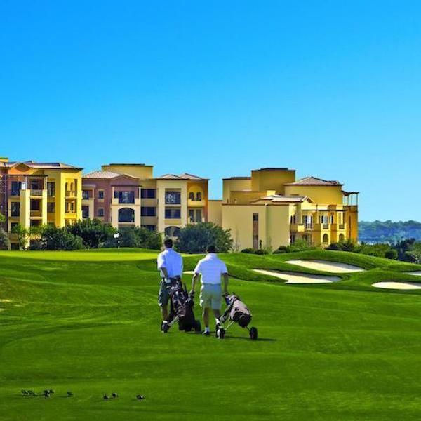 The Residence at Victoria Golf apartments with golfers on Victoria Golf in foreground